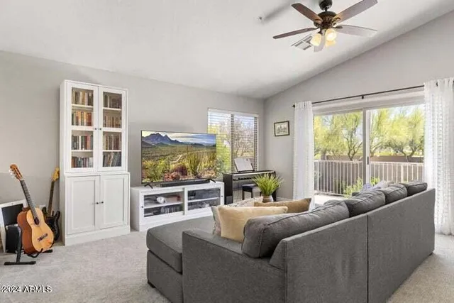 a living room with furniture a flat screen tv and a large window