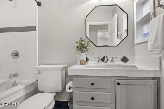 a bathroom with a sink a toilet and a mirror