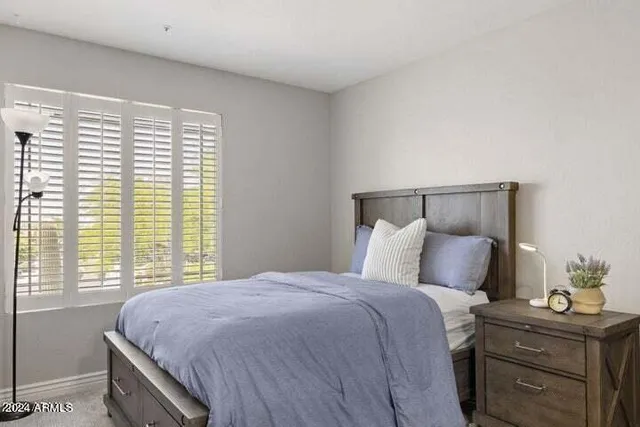 a bed sitting in a bedroom next to a window