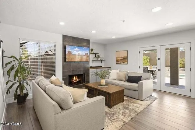 a living room with furniture a fireplace and a large window