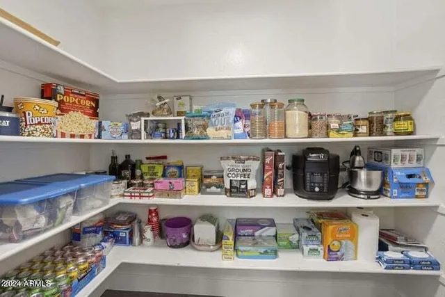 a cabinet with granite countertop lots of different kinds of food