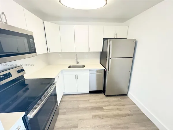 a kitchen with a refrigerator sink stove and cabinets