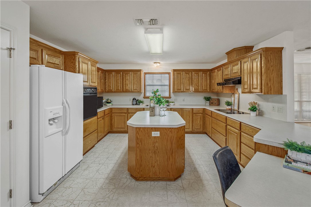 1110 County Road 439 Dime Box, TX 77853 - Photo 19 of 50 a kitchen with stainless steel appliances granite countertop a refrigerator a sink dishwasher a stove with wooden cabinets and a granite counter top