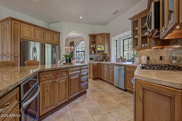 a kitchen with stainless steel appliances granite countertop a sink and cabinets