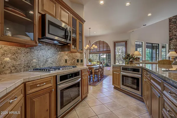 a kitchen with stainless steel appliances granite countertop a stove top oven microwave and cabinets