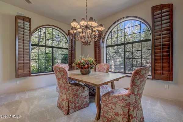 a view of a dining room with furniture a chandelier and wooden floor