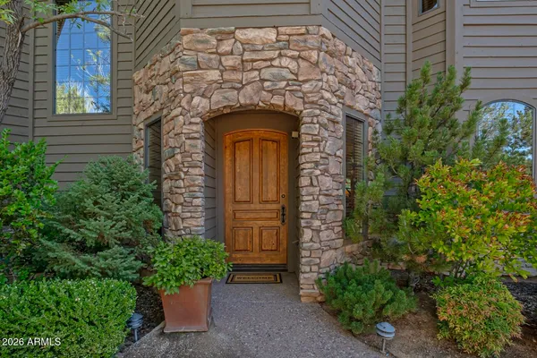 a stone house with potted plants in front of door