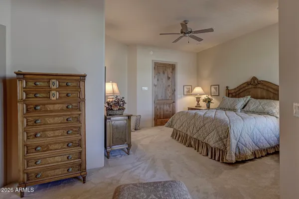 a bedroom with a bed and a ceiling fan