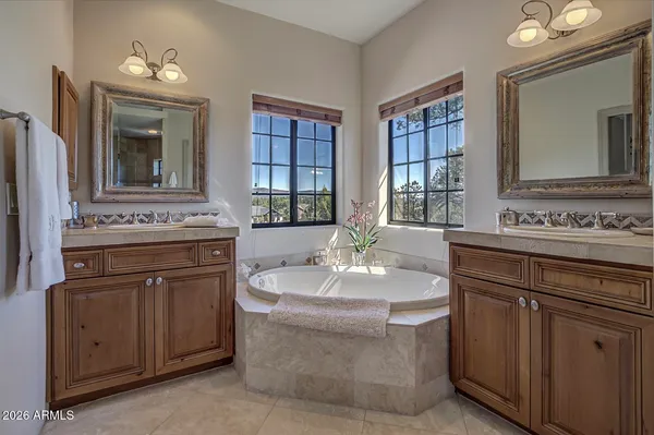 a spacious bathroom with a sink double vanity granite and a mirror