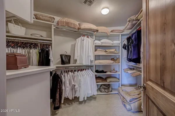 a view of walk in closet with clothes and shoes