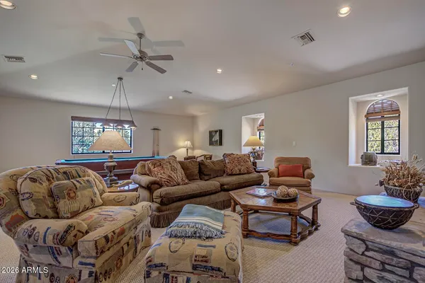 a living room with furniture a chandelier and a window