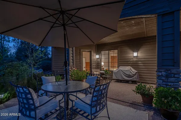 a patio with a table and chairs under an umbrella