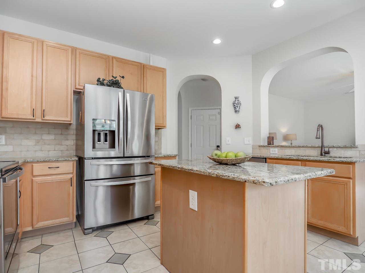 8507 Flying Buttress Drive Raleigh, NC 27613 - Photo 3 of 27 A bright and airy kitchen with granite countertops, stainless steel appliances and tile flooring.