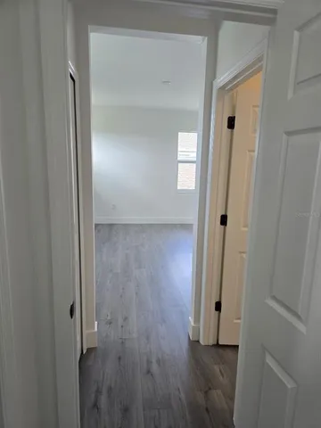 a view of a hallway with wooden floor
