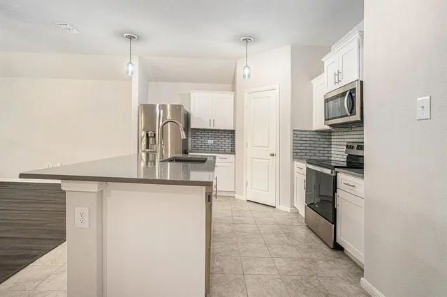 a kitchen with stainless steel appliances granite countertop a refrigerator and a stove