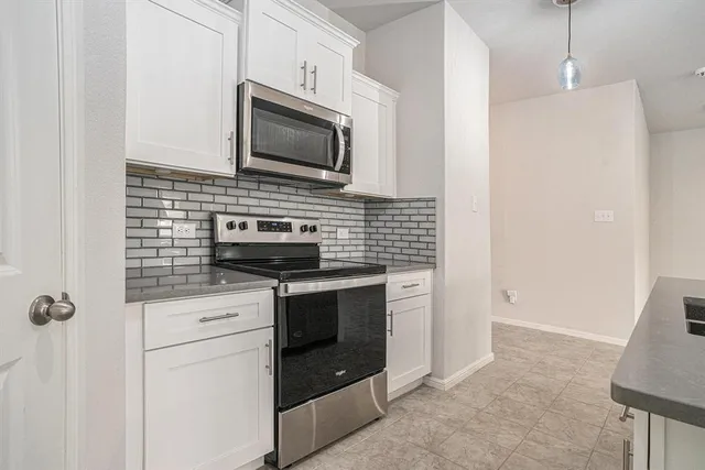 a kitchen with stainless steel appliances a stove microwave and refrigerator