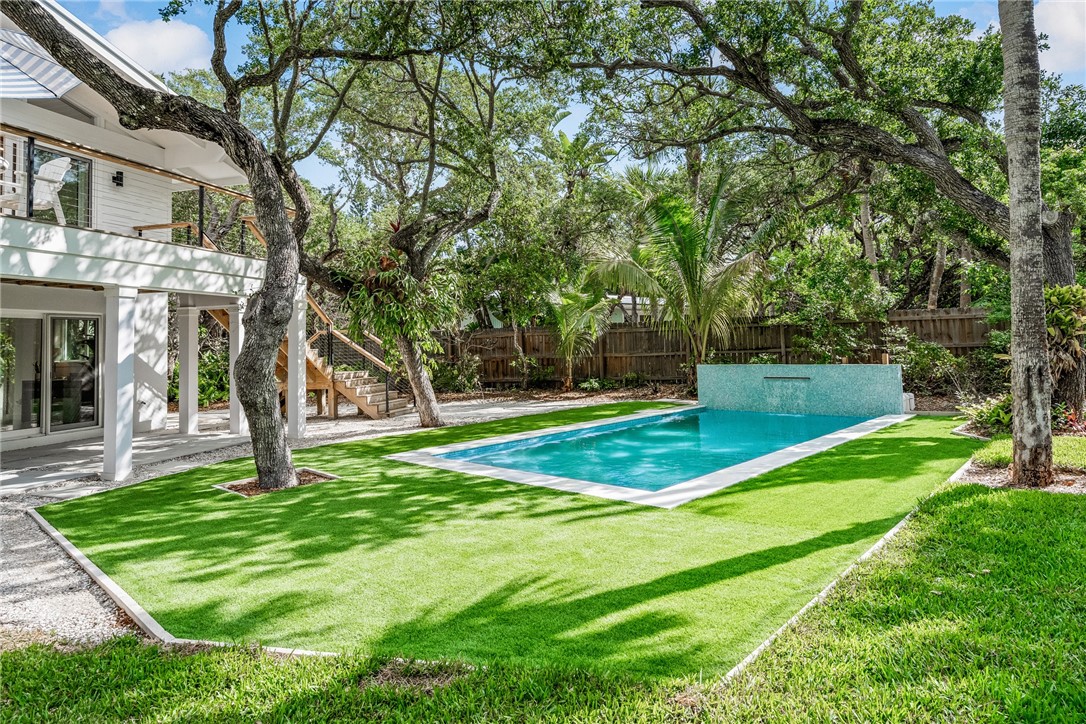 a view of a house with a yard deck and a slide