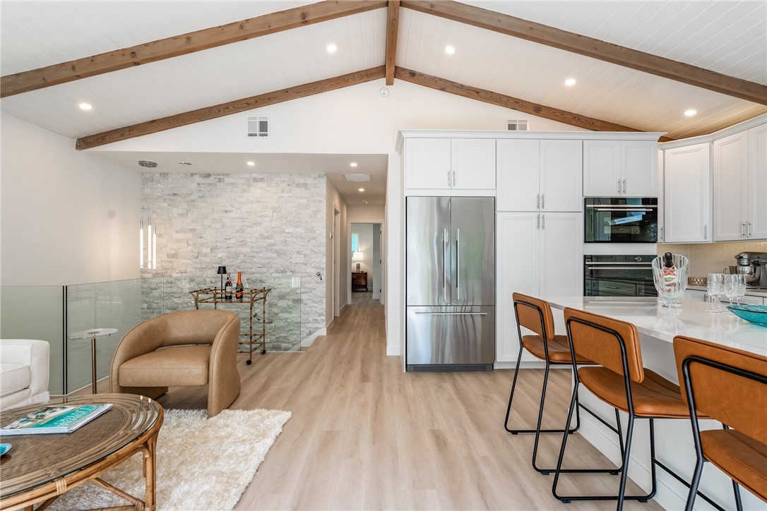 1881 Pebble Path Vero Beach, FL 32963 - Photo 10 of 34 a kitchen with stainless steel appliances kitchen island granite countertop a refrigerator a stove a sink a dining table and chairs with wooden floor