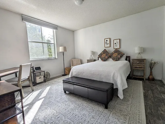 a bedroom with a bed a table and a window