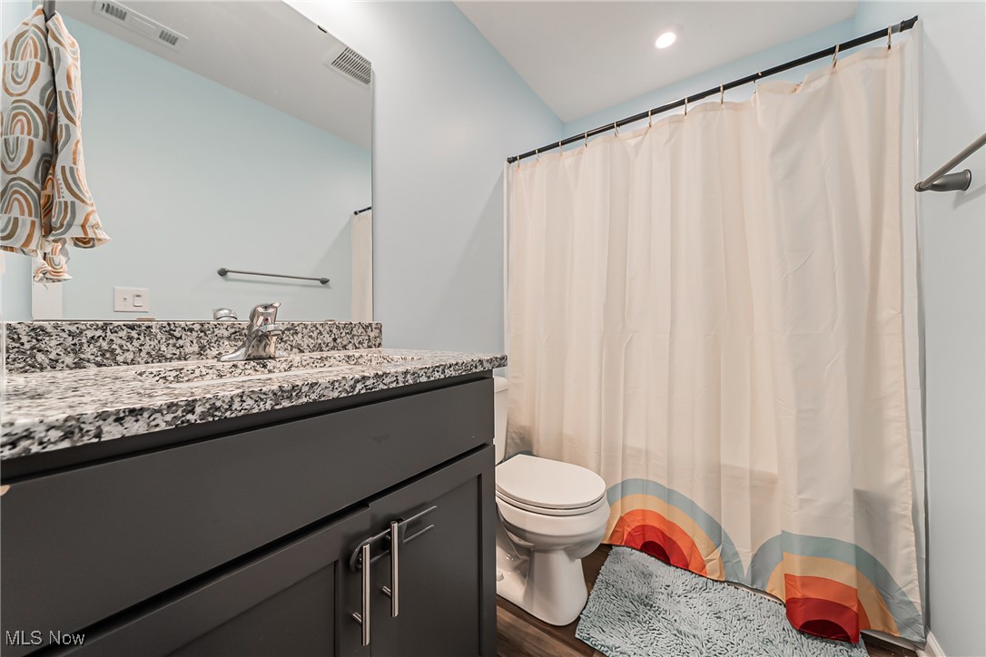 6105 Dunham Road Maple Heights, OH 44137 - Photo 20 of 38 Bathroom with toilet, vanity, wood finished floors, and a shower with curtain