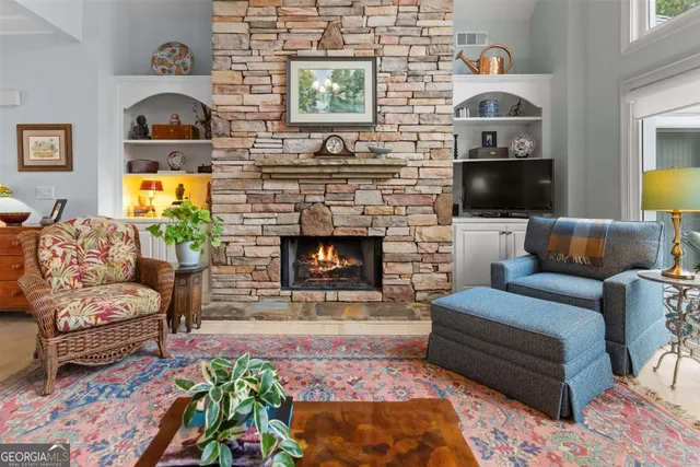 a living room with furniture fireplace and a large window