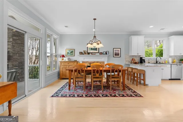 a view of a dining room with furniture a chandelier and wooden floor