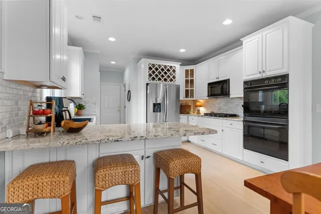 a kitchen with stainless steel appliances white cabinets a window and a sink
