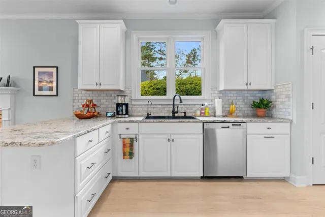 a kitchen with stainless steel appliances granite countertop a refrigerator stove and white cabinets
