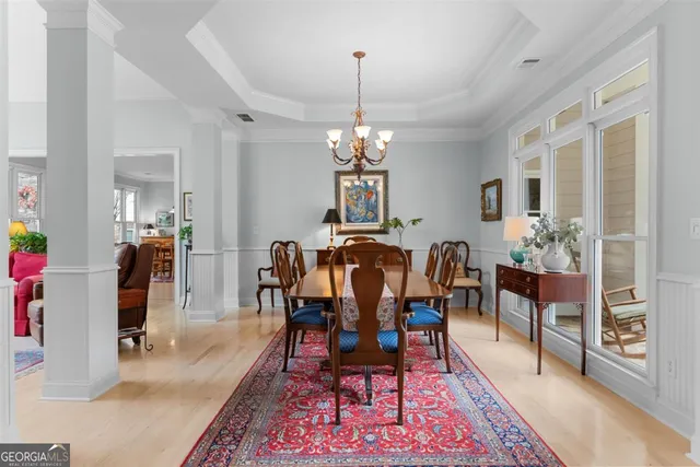 a view of a dining room with furniture a chandelier and wooden floor