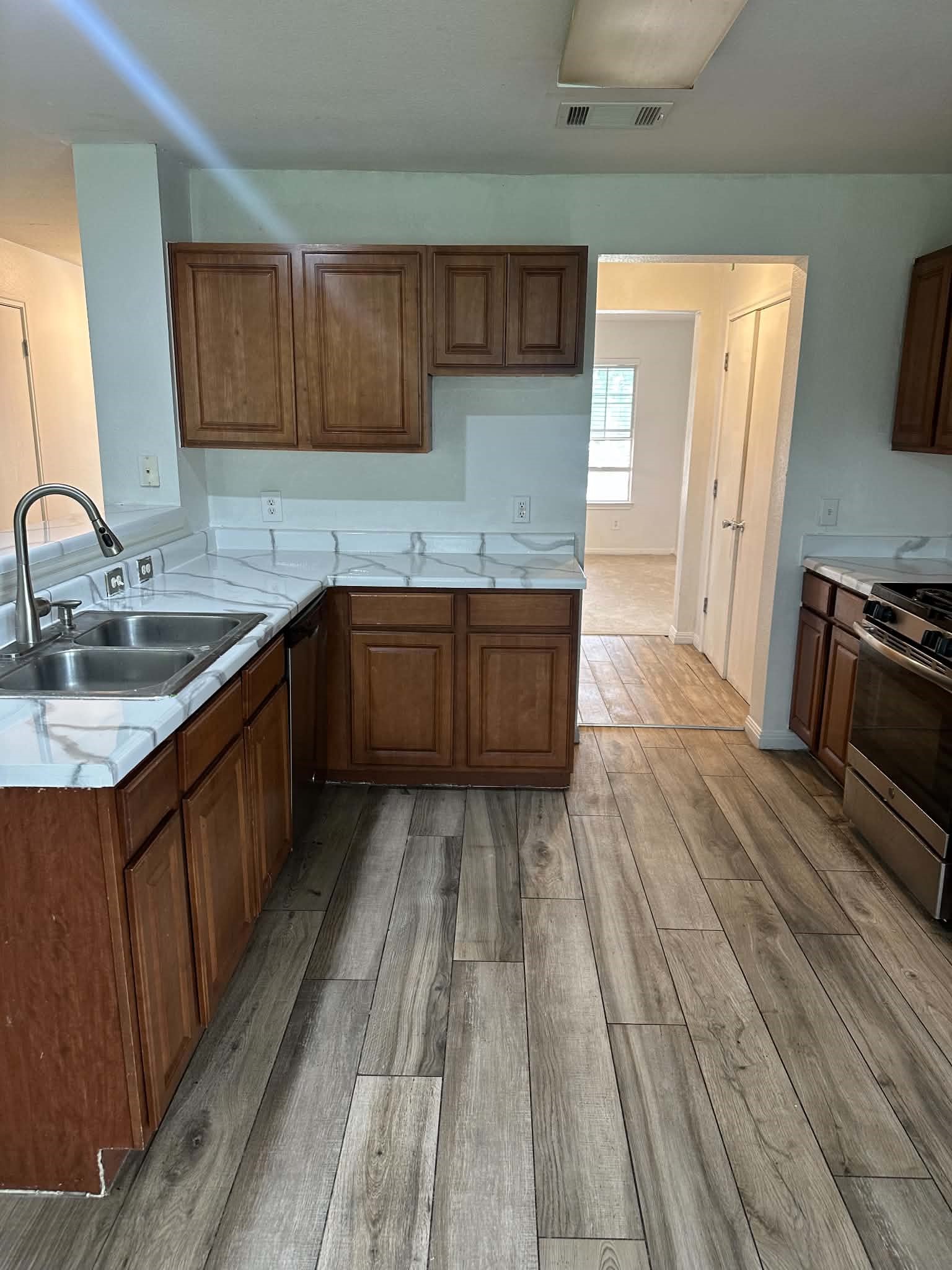 18312 Crestwind Lane Elgin, TX 78621 - Photo 6 of 15 A well-appointed kitchen showcasing contemporary wood-look tile flooring and sleek counters.