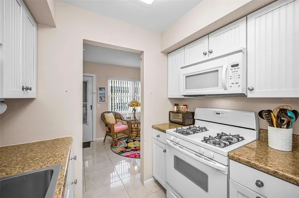 a kitchen with granite countertop a sink and a stove