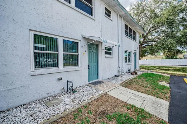 a living room with furniture a chandelier and kitchen view