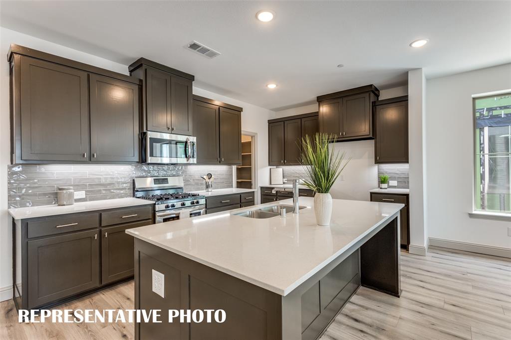 2857 Chisos Red Road McKinney, TX 75071 - Photo 4 of 13 a kitchen with a sink cabinets and wooden floor