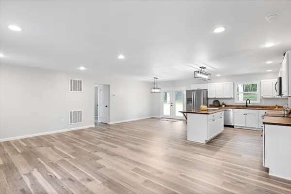 a open kitchen with white cabinets and white appliances