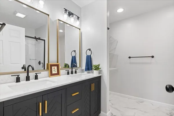 a bathroom with a double vanity sink a mirror and shower