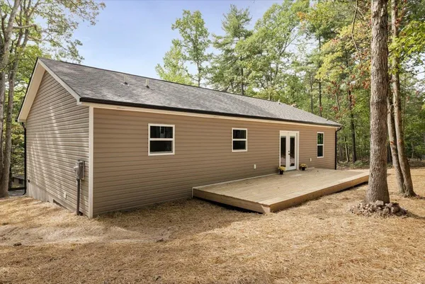 a view of a house with a backyard and trees