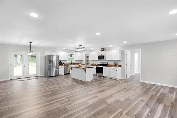 a large kitchen with a center island and wooden floor