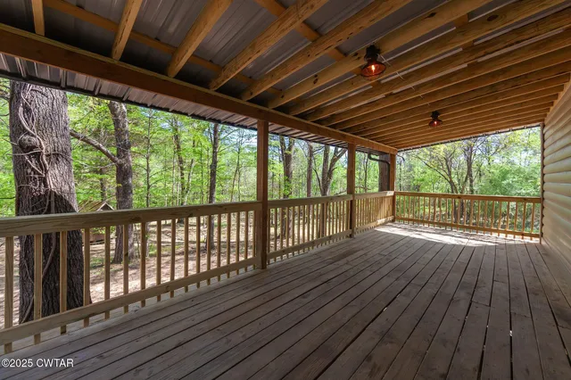 an aerial view of residential house with outdoor space and trees all around