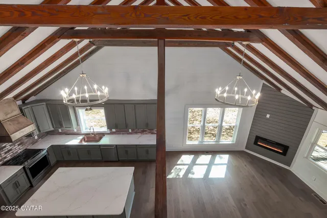 a kitchen with stainless steel appliances kitchen island granite countertop a sink a stove and cabinets