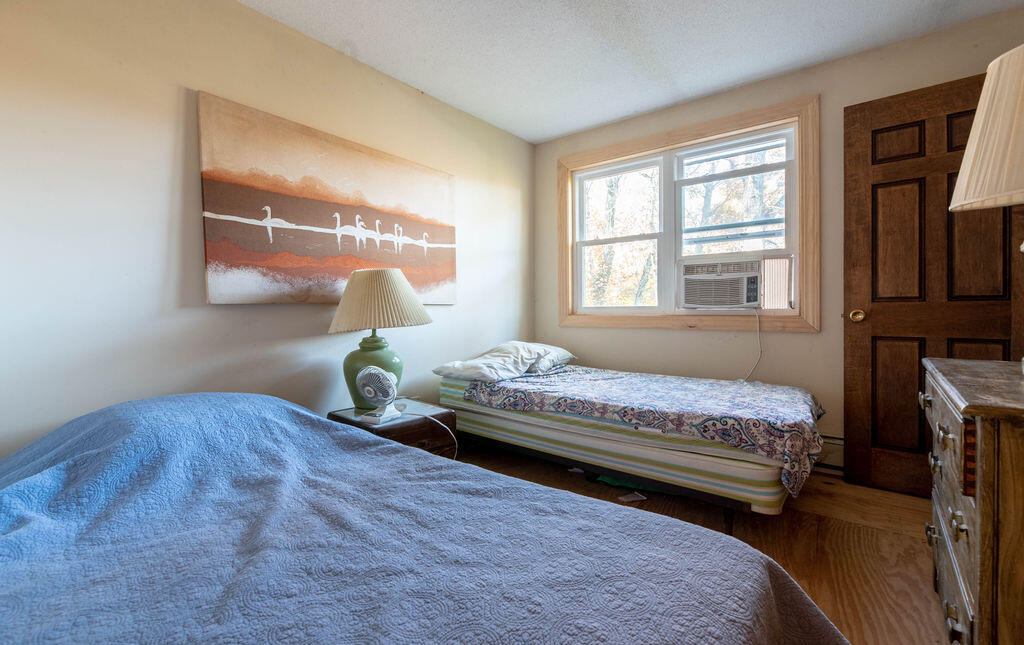 44 Deerfield Road Mashpee, MA 02649 - Photo 10 of 17 a bedroom with a bed and wooden floor