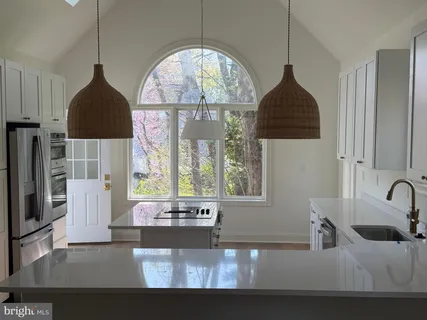 a kitchen with a sink a window and a wooden floor