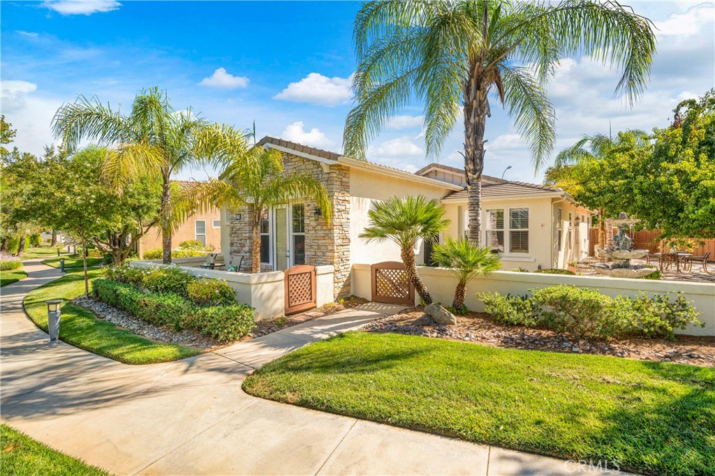 a view of a house with a yard and palm trees