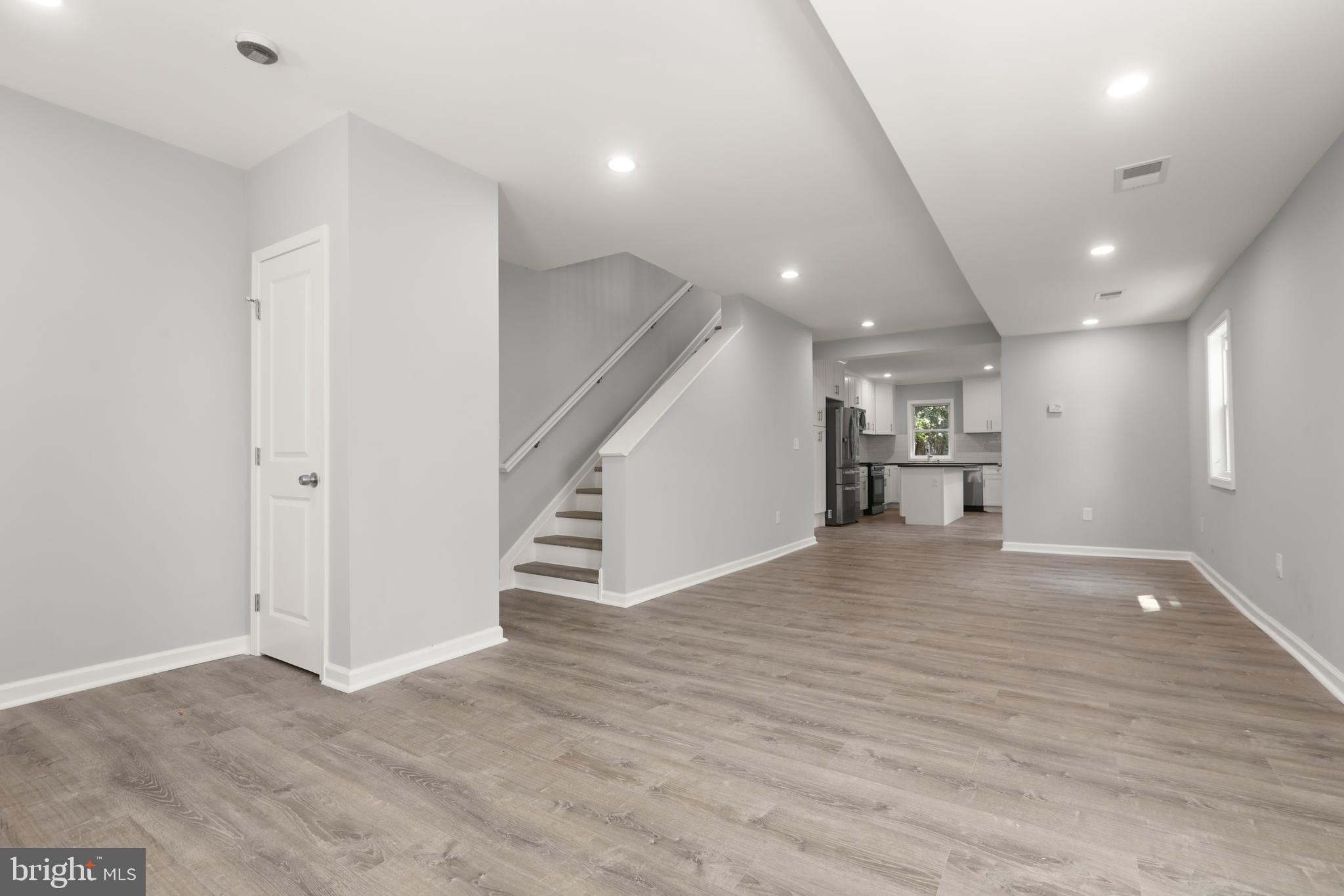 4015 Evans Chapel Road Baltimore, MD 21211 - Photo 11 of 50 an empty room with wooden floor and stairs
