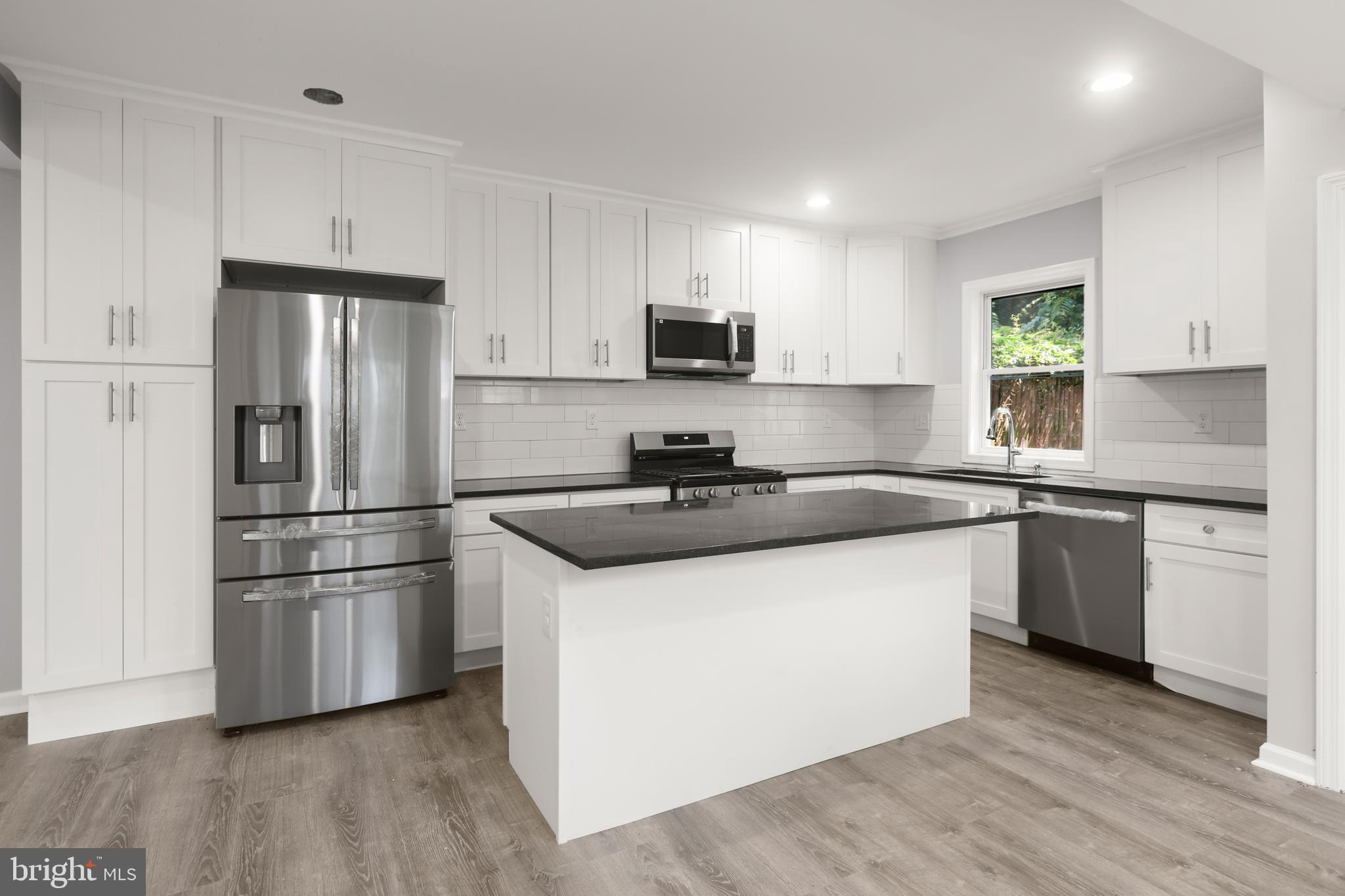4015 Evans Chapel Road Baltimore, MD 21211 - Photo 15 of 50 a kitchen with stainless steel appliances a sink a stove a refrigerator and cabinets