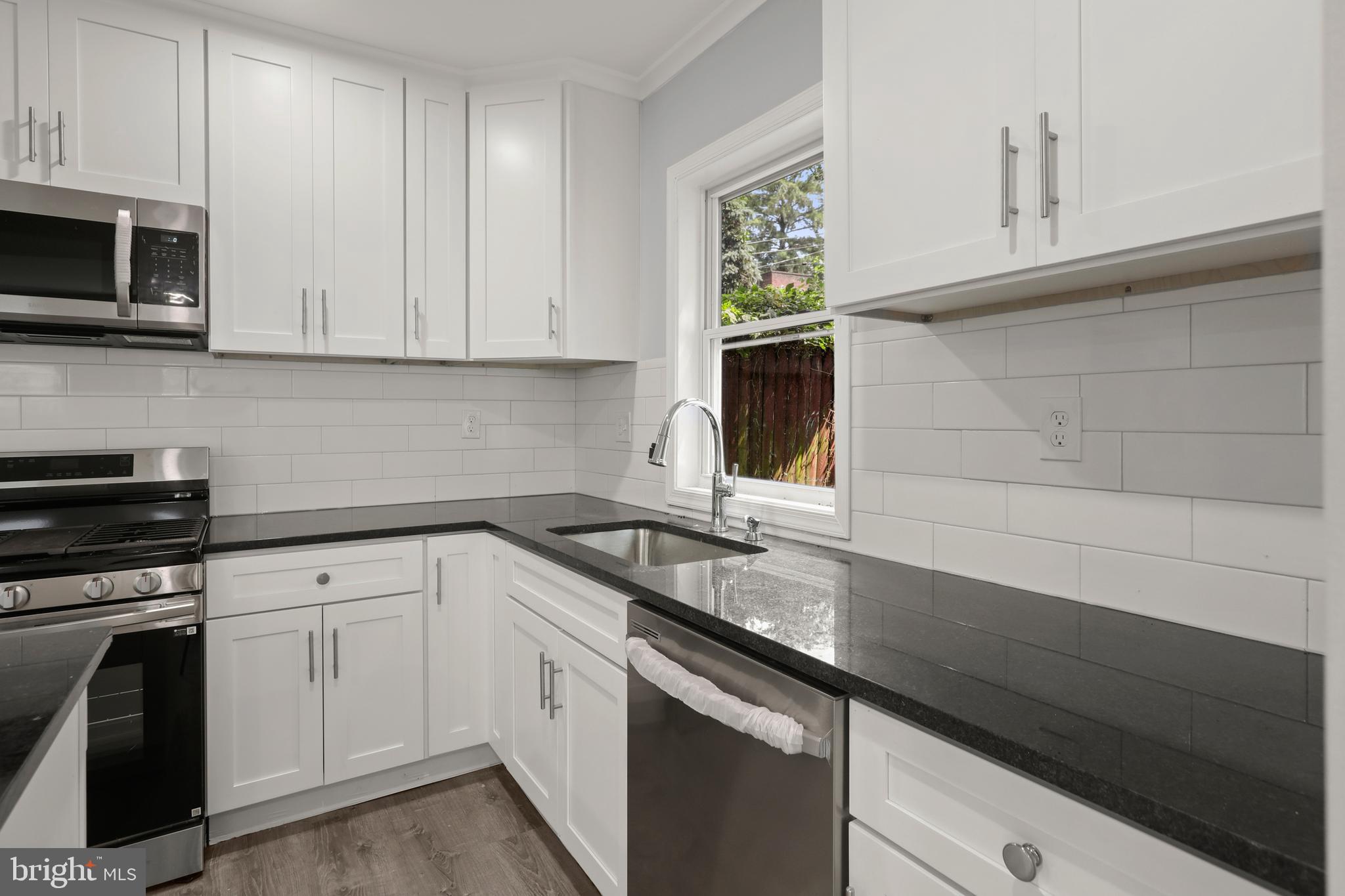 4015 Evans Chapel Road Baltimore, MD 21211 - Photo 18 of 50 a kitchen with granite countertop white cabinets and a sink