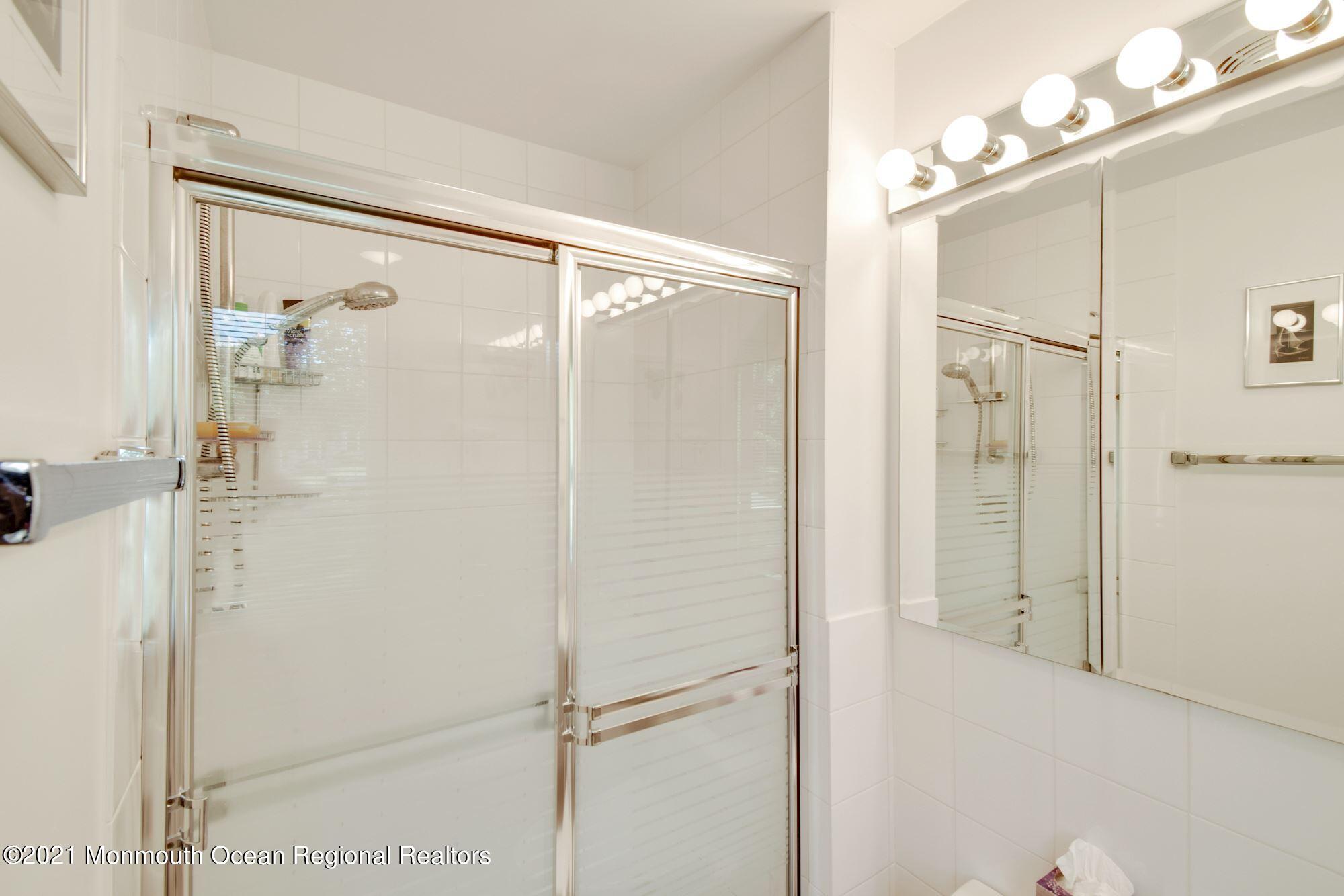 36 Coldspring Road Freehold, NJ 07728 - Photo 21 of 37 a bathroom with a glass shower door and a mirror