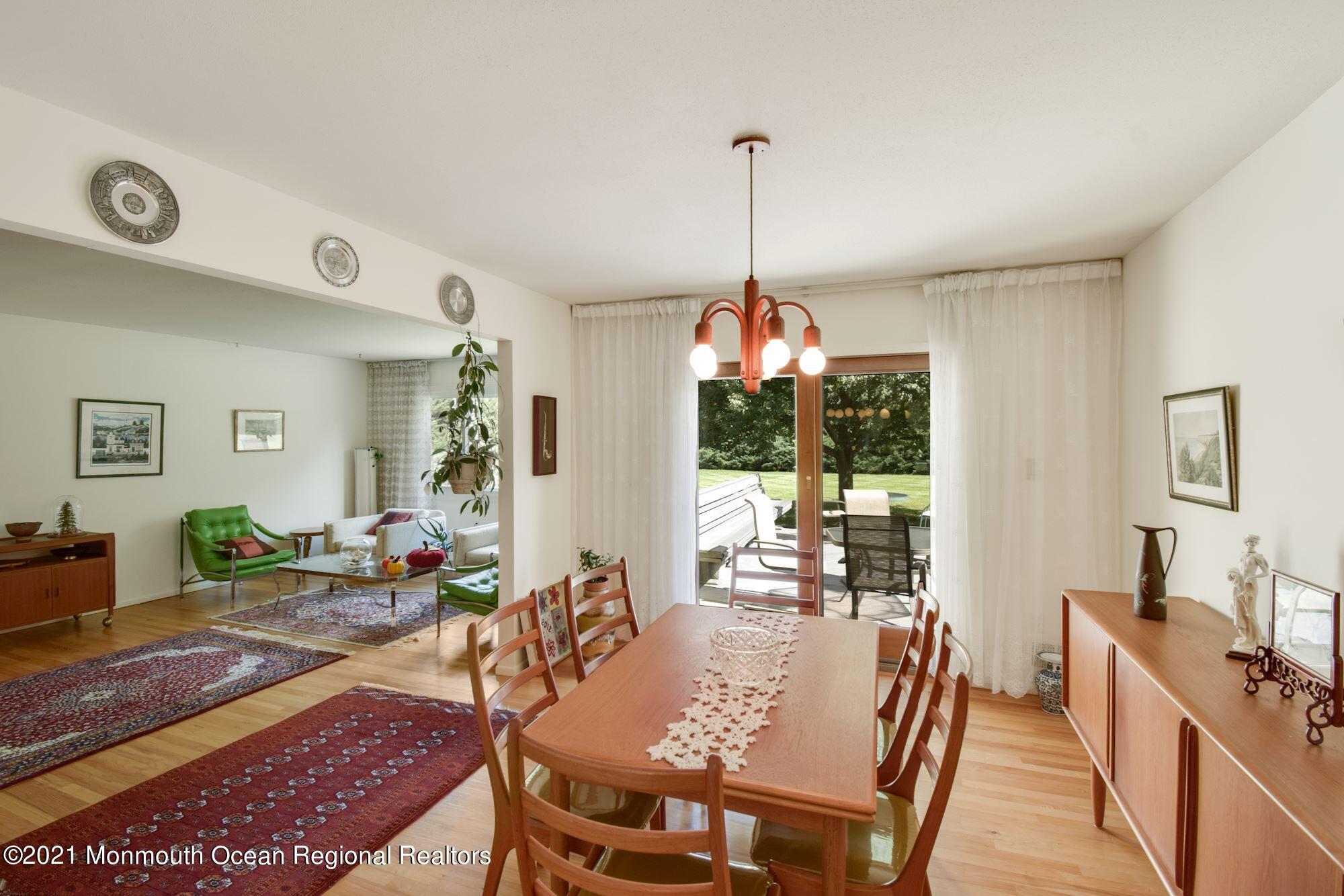 36 Coldspring Road Freehold, NJ 07728 - Photo 8 of 37 a view of a dining room and livingroom with furniture wooden floor a rug a potted plant and a chandelier