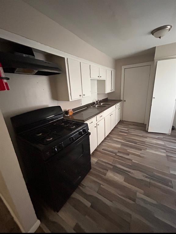 3149 Fulton Street Shreveport, LA 71109 - Photo 5 of 7 Kitchen with gas stove, exhaust hood, dark countertops, white cabinets, and dark wood-style floors