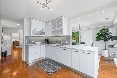 a kitchen with a sink a counter top space appliances and cabinets