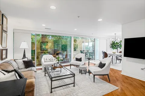 a living room with furniture a flat screen tv and a large window